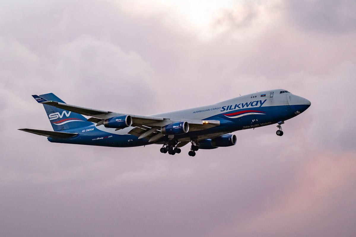 Silk Way West Airlines Jumbo Jet Boeing 747-400F freight edition cargo aircraft as seen flying and landing at Amsterdam Schiphol Airport AMS EHAM during a dark cloudy evening. The Boeing 747 plane has the registration 4K-SW008. Silk Way West Airlines is an Azerbaijani cargo airline with its head office and main operating base at Heydar Aliyev International Airport in Baku, Azerbaijan. Cargo flights have increased demand and fly more as the passenger aviation industry traffic is phasing a difficult period with the Covid-19 coronavirus pandemic having a negative impact on the travel business industry with fears of the worsening situation due to the new Omicron variant mutation. Amsterdam, the Netherlands on January 5, 2022