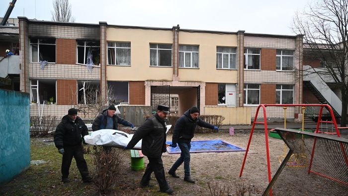 EDITORS NOTE: Graphic content / Four men carry a bag with a body at the site where a helicopter crashed near a kindergarten in Brovary, outside the capital Kyiv, killing Sixteen people, including two children and Ukrainian interior minister, on January 18, 2023, amid the Russian invasion of Ukraine. (Photo by Sergei Supinsky / AFP)