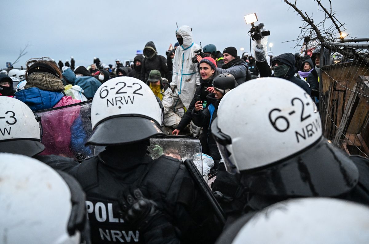 Police face activists as they start the evacuation of the village of Luetzerath, western Germany, on January 11, 2023, while anti-coal activists stage an "active defence" of the village, which is slated for forced evacuation, ahead of a planned demolition to expand a coal mine. - Police have secured approval from the state interior ministry to clear the village but activists have warned there will be "no limits" in Luetzerath, a village in North Rhine-Westphalia state, was once home to around 100 people but has been abandoned over the years as uncertainty hung over its planned evacuation for the expansion of the neighbouring coal mine Garzweiler.