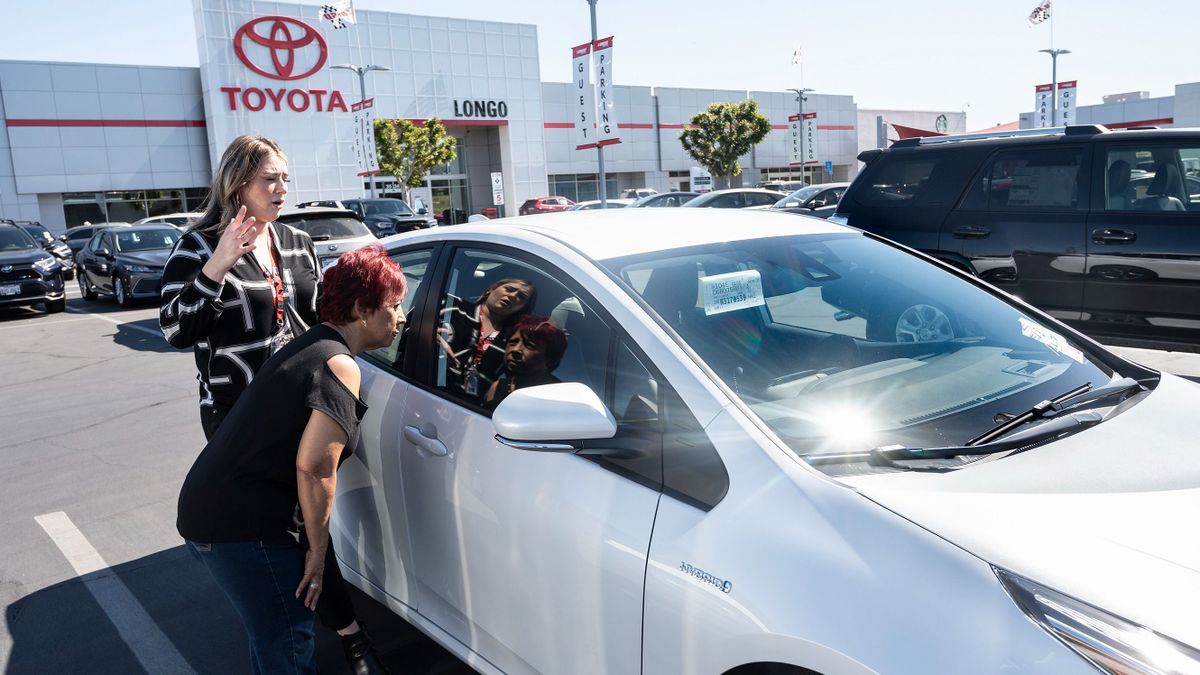 El Monte, CA - March 23: A customer is shown a 2022 Toyota Prius at Longo Toyota in El Monte, CA on Wednesday, March 23, 2022. With gasoline prices hitting record highs dealerships are trying to keep electric, fuel cell and hybrid cars in stock.