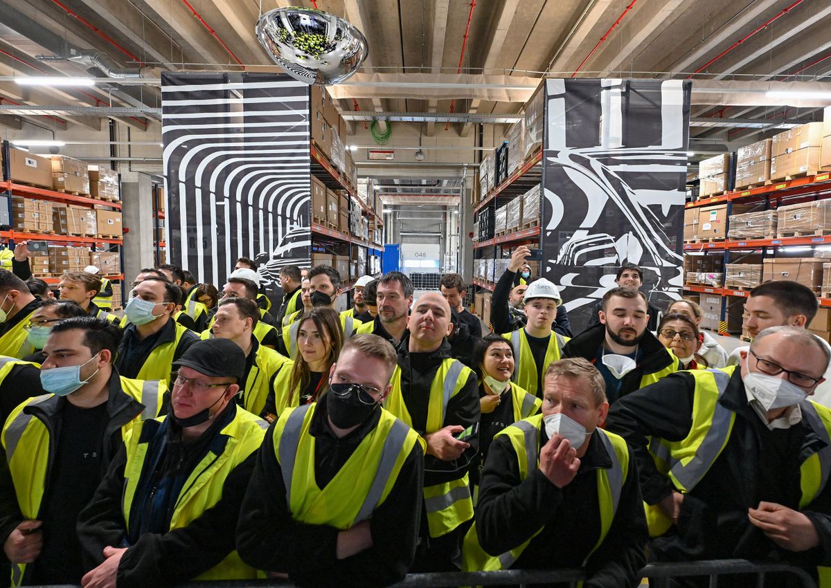 22 March 2022, Brandenburg, Grünheide: Tesla employees attend the opening of the Tesla factory Berlin Brandenburg. The first European factory in Grünheide, which is designed for 500,000 vehicles per year, is an important pillar of Tesla's future strategy. Photo: Patrick Pleul/dpa-Zentralbild POOL/dpa (Photo by PATRICK PLEUL / dpa-Zentralbild POOL / dpa Picture-Alliance via AFP)