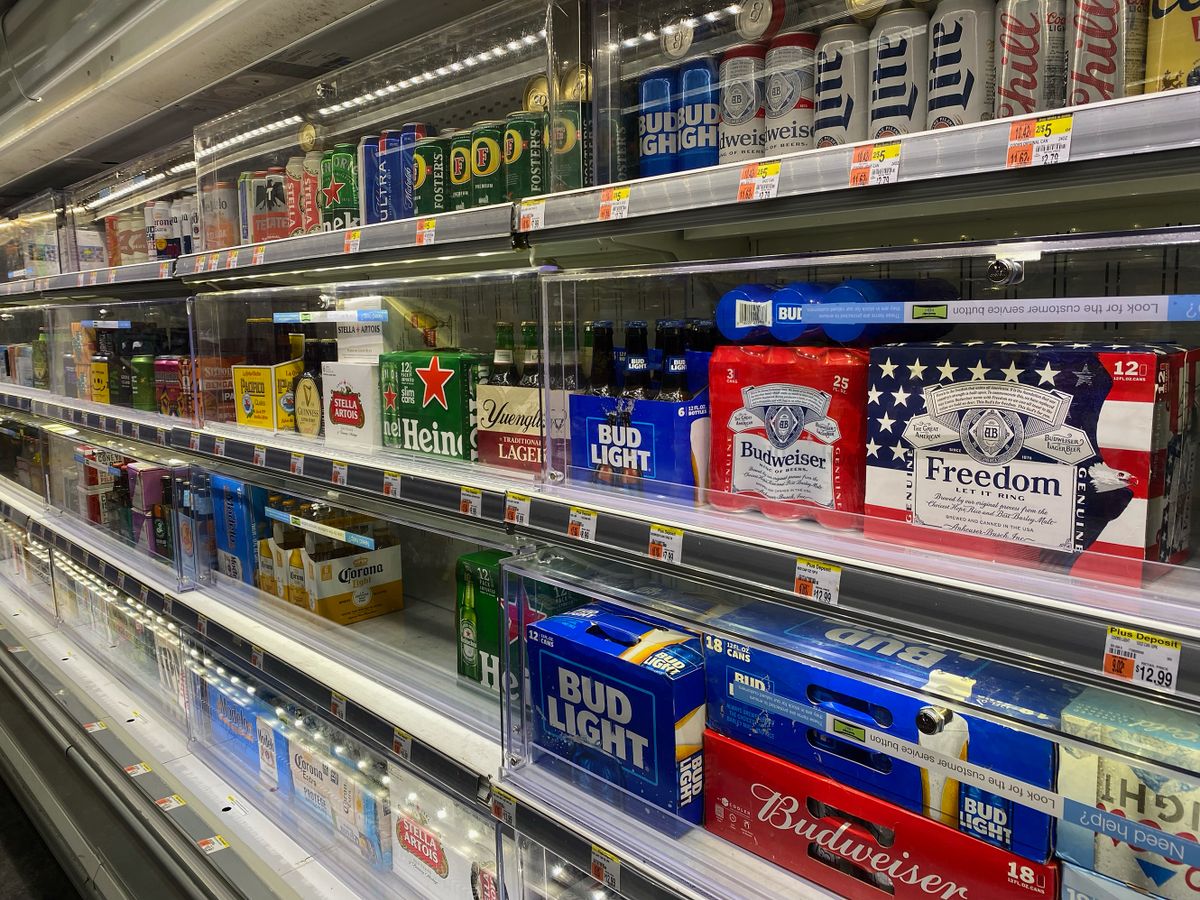 Beer displayed in a locked refrigerator at Whole Foods, supermarket, ask for customer assistance, Manhattan, New York.
