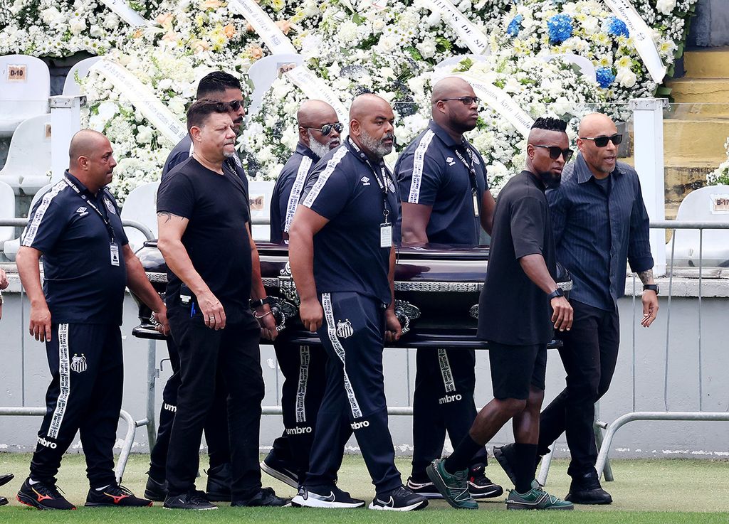 SANTOS, BRAZIL - JANUARY 02: Edinho (R), son of Pelé and former football player Ze Roberto carry Pele's coffin into Urbano Caldeira Stadium for his funeral on January 02, 2023 in Santos, Brazil. Brazilian football icon Edson Arantes do Nascimento, better known as Pele, died on December 29, 2022 aged 82 after a battle with cancer in Sao Paulo, Brazil. The three-time World Cup champion with Brazil is considered one of the greatest soccer legends of all time. (Photo by Mario Tama/Getty Images)