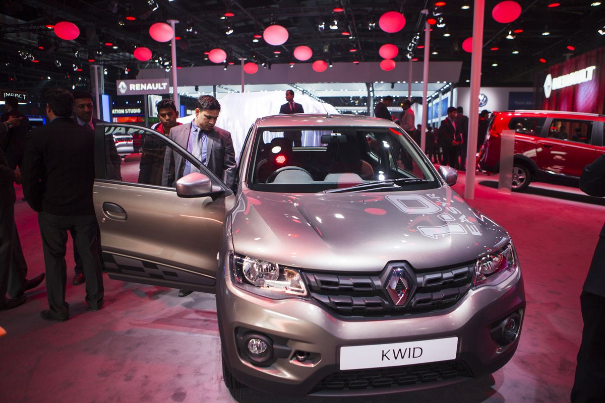 Attendees look at the Renault SA Kwid compact vehicle on display at the Auto Expo 2016 in Noida, Uttar Pradesh, India, on Thursday, Feb. 4, 2016. The motor show opened to the public today and runs through Feb. 9. 