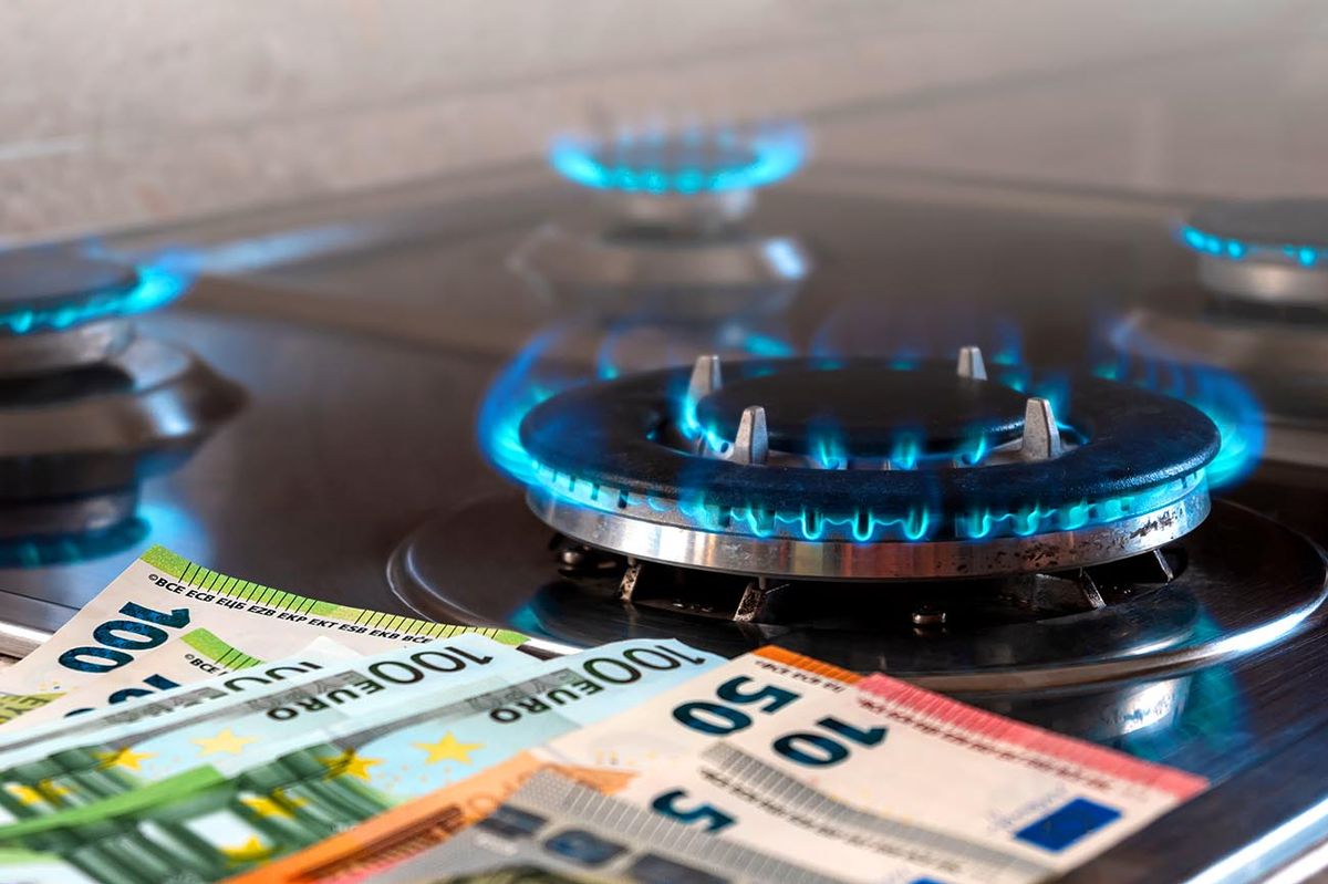 The,Banknotes,Lie,Next,To,A,Burning,Gas,Burner.,The The banknotes lie next to a burning gas burner. The concept is to increase the cost of supply , payment for natural gas. The energy crisis. High cost, price of gas.