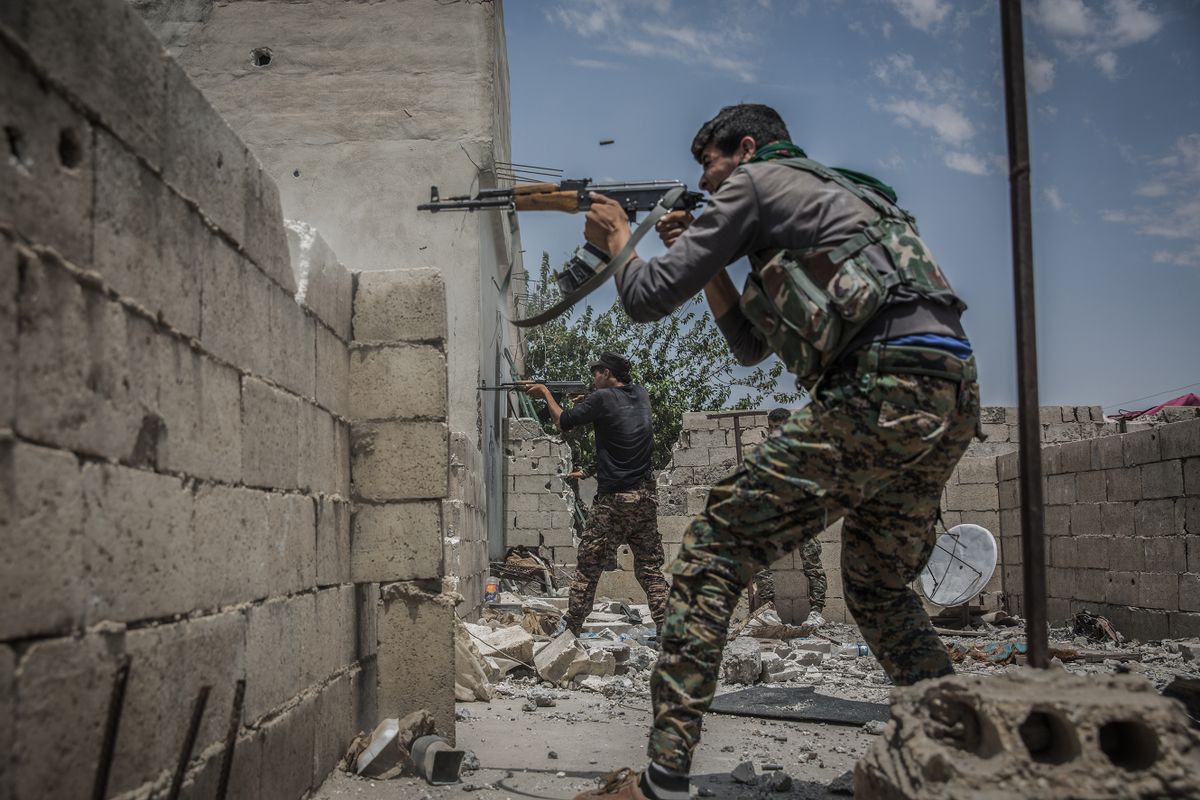 Fighters of the People's Protection Units (YPG), a mainly-Kurdish militia in Syria, fires their guns towards positions of militants of the so called Islamic State (IS) in Al Sinaa neighborhood, eastern Raqqa, Syria, 06 July 2017. Syrian activists say Islamic State group fighters are battling to repel the advance of U.S.-backed Syrian forces days after they brought the fight to the heart of the militant group's de-facto capital. 