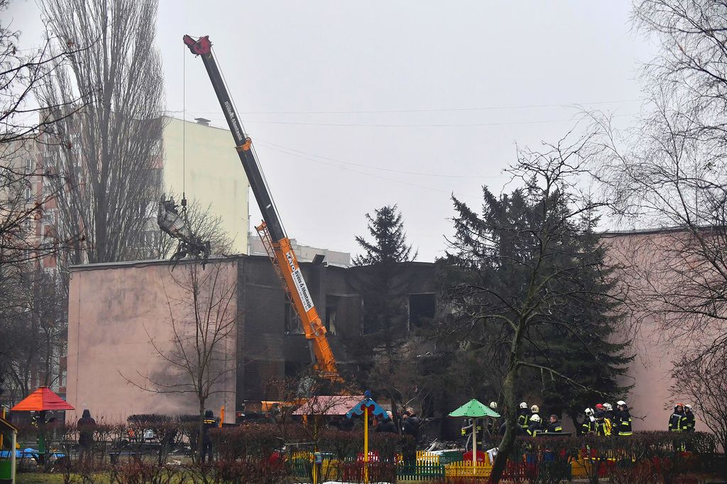 A part of a helicopter that crashed near a kindergarten is removed as rescuers work in Brovary, outside the capital Kyiv, on January 18, 2023, amid the Russian invasion of Ukraine. - Eighteen people, including Ukraine´s interior minister and three children, were killed in a helicopter crash near a kindergarten outside Kyiv on January 18, 20223. (Photo by Sergei SUPINSKY / AFP)