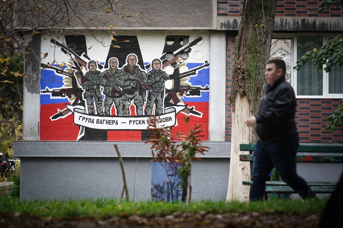 A pedestrian walks past a mural depicting Russia's para military mercenaries 'Wagner Group' reading : "Wagner Group - Russian knights" on a building's wall in Belgrade, on November 17, 2022. - A group of Russian children of all ages clamour cheerfully in a Belgrade apartment, proudly shouting out the new Serbian words they learned to their teacher.These kids all have one thing in common. Their parents fled the country after Russian President Vladimir Putin's invasion of Ukraine and are now preparing to stay in the Balkan country for the long haul.
