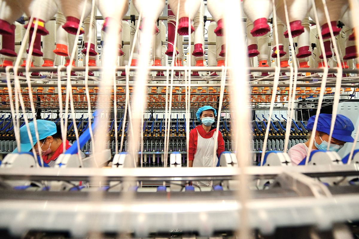 Textile Factory In Yudu YUDU, CHINA - DECEMBER 30: Employees operate a spinning machine at a textile factory on December 30, 2022 in Yudu County, Ganzhou City, Jiangxi Province of China. (Photo by Zhu Haipeng/VCG via Getty Images), Kína, szolgáltatóipar