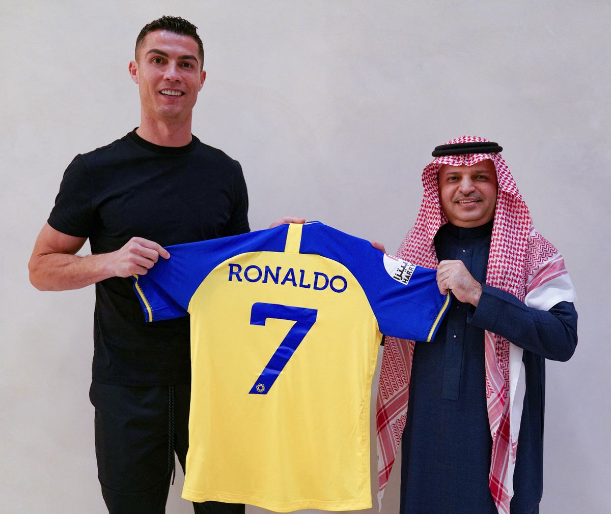 A handout picture released by Saudi Arabia's al-Nasr football club shows Portugal's forward Cristiano Ronaldo being presented with the club's number seven jersey by club president Musalli Al-Muammar in Madrid on December 30, 2022 upon signing for the Saudi Arabian club. - Cristiano Ronaldo on December 30 signed for al-Nasr of Saudi Arabia, the club announced, in a deal believed to be worth more than 200 million euros. The 37-year-old penned a con