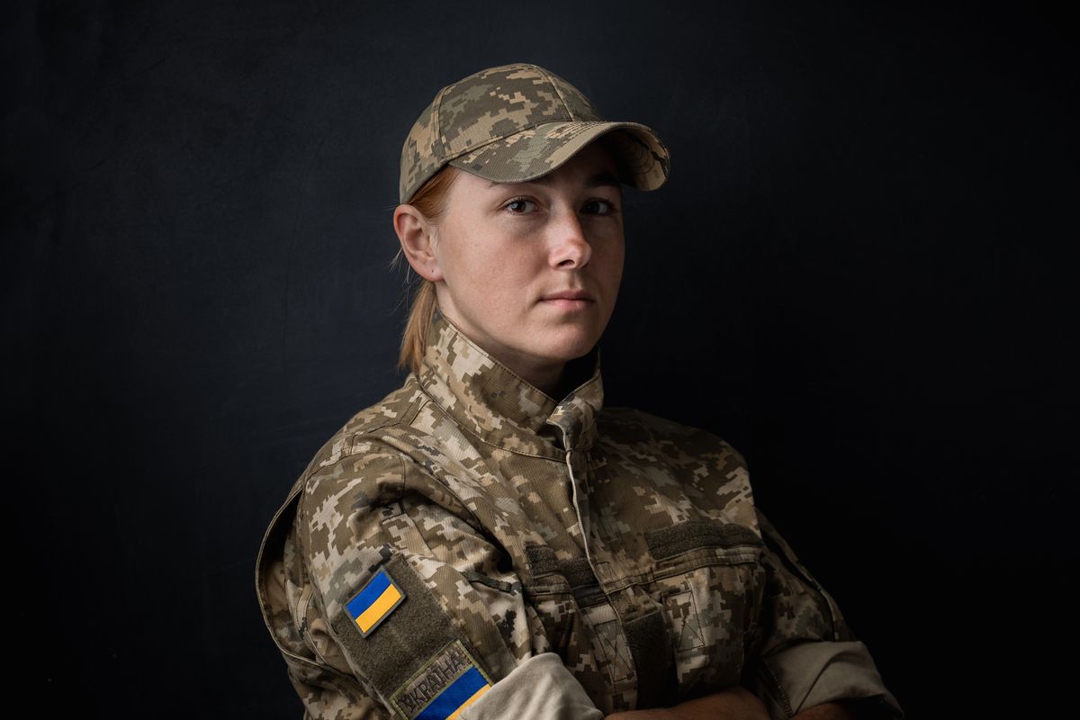Portrait of beautiful girl with yellow and blue Ukrainian flag on her cheek wearing military uniform. Ukrainian women in the army. Black background. Stand with Ukraine
hadköteles ukrán nő Ukrajna