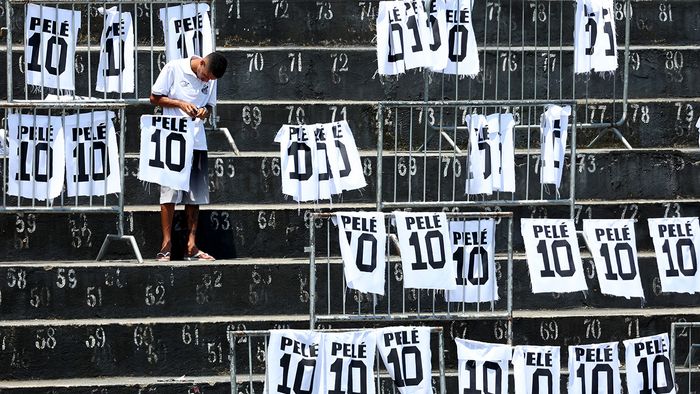 SANTOS, BRAZIL - JANUARY 02: A worker adjusts Pele signs at Urbano Caldeira Stadium during football legend Pele's funeral on January 02, 2023 in Santos, Brazil. Brazilian football icon Edson Arantes do Nascimento, better known as Pele, died on December 29, 2022 aged 82 after a battle with cancer in Sao Paulo, Brazil. The three-time World Cup champion with Brazil is considered one of the greatest soccer legends of all time. (Photo by Mario Tama/Getty Images)