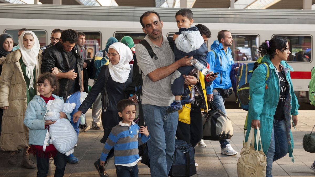 Munich, Germany - September 10, 2015: Refugees from Syria, Afghanistan and Balkan countries hopping on the next train at the main station in Munich.