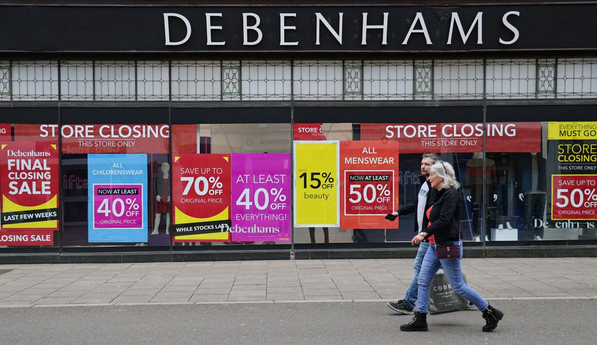 Signs in the window of a closing Debenhams store offer sales bargains on the High Street in Winchester, south west England on March 31, 2021.