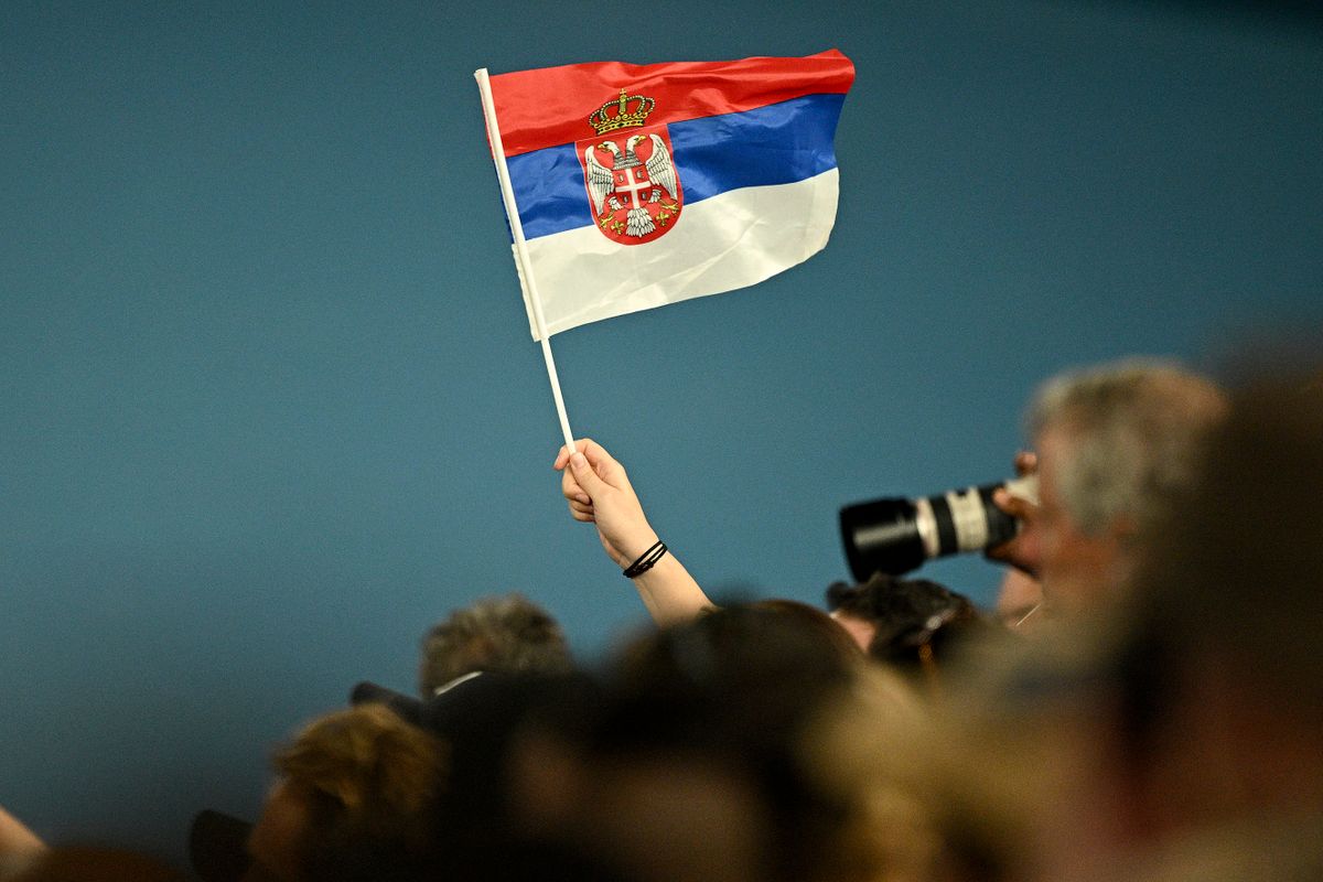 A fan of Serbia's Novak Djokovic waves the national flag during his men's singles match  against Australia's Alex De Minaur on day eight of the Australian Open tennis tournament in Melbourne on January 23, 2023. 