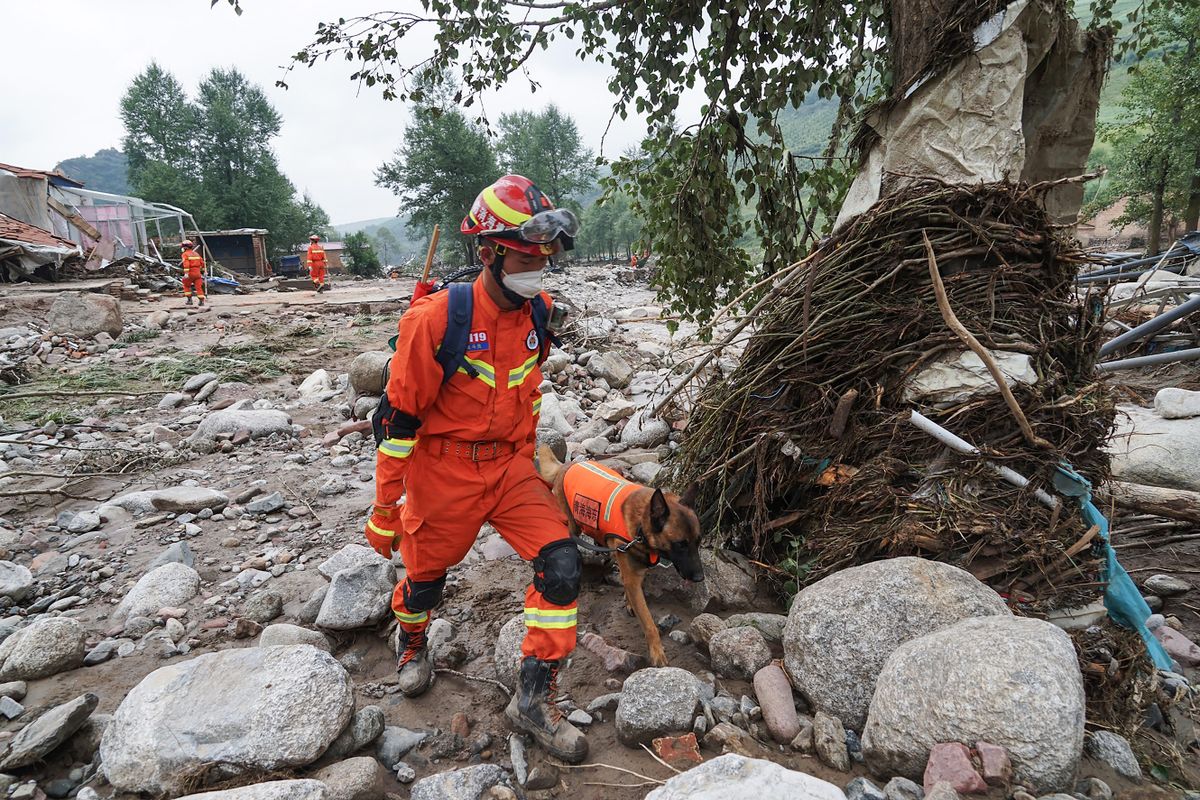 Rescue workers conduct a search a day after a flash flooding caused by a sudden downpour triggered mudslides in Datong county, Xining city, in China's northwestern Qinghai province on August 19, 2022. 