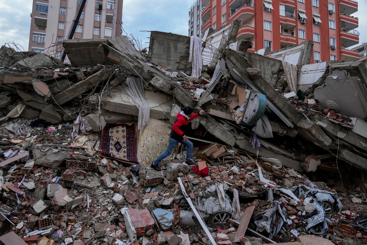 Adana, 2023. február 6.Férfi egy összedőlt épület törmelékhalmán a dél-törökországi Adana nagyvárosban 2023. február 6-án. Hajnalban több erős földrengés rázta meg Törökország délkeleti és Szíria északi részét, a legnagyobb rengés egyes mérések szerint a 7,8-as erősséget is elérte. A földmozgásnak Törökországban és Szíriában is több száz halálos áldozata és több ezer sérülje van.