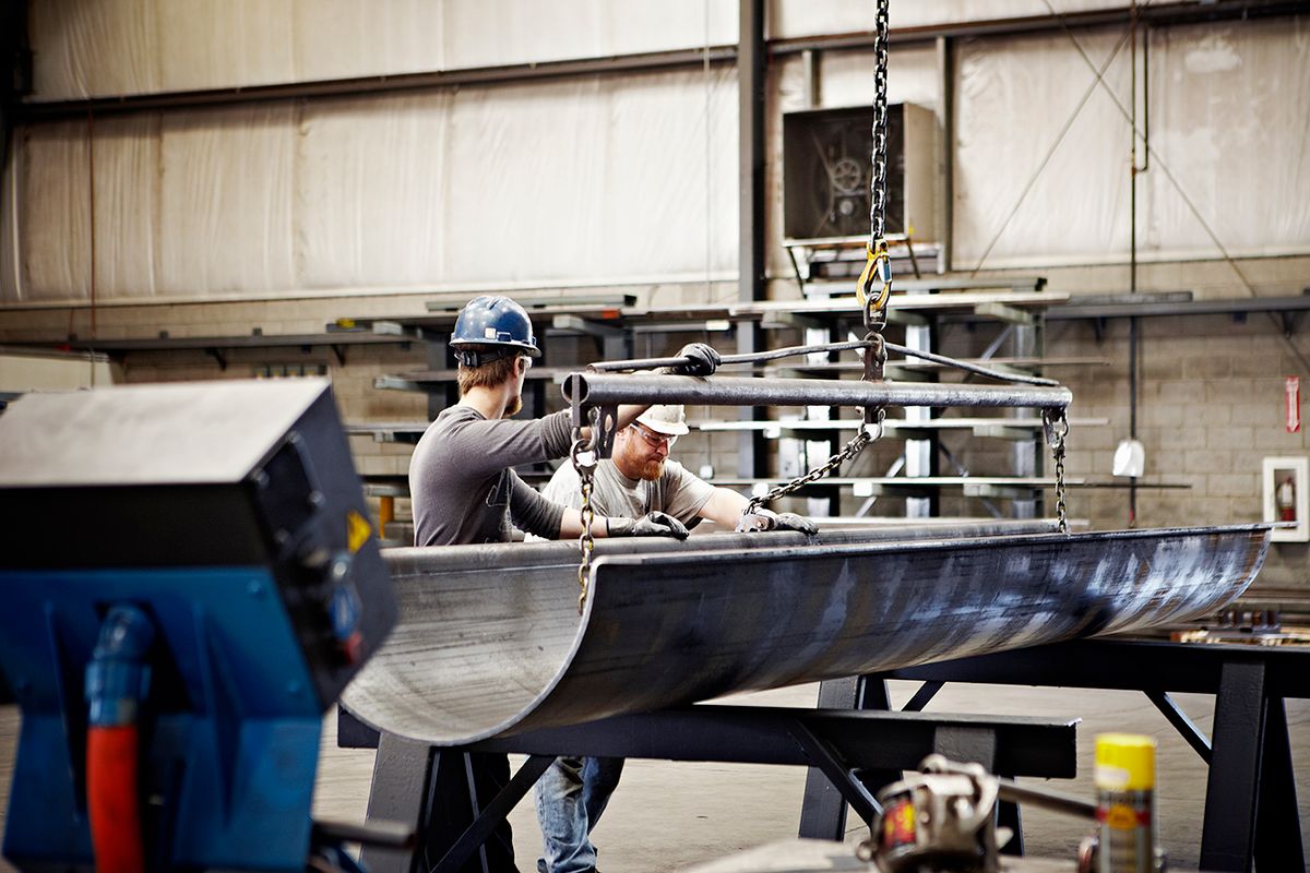 Steel workers adjusting position of formed steel
Steel workers adjusting position of brake press formed steel with crane