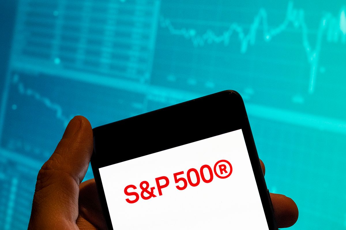 In this photo illustration, the US stock market index
CHINA - 2023/02/19: In this photo illustration, the US stock market index tracking the stock performance of 500 large companies listed S&P 500 logo is seen displayed on a smartphone with an economic stock exchange index graph in the background. (Photo Illustration by Budrul Chukrut/SOPA Images/LightRocket via Getty Images)