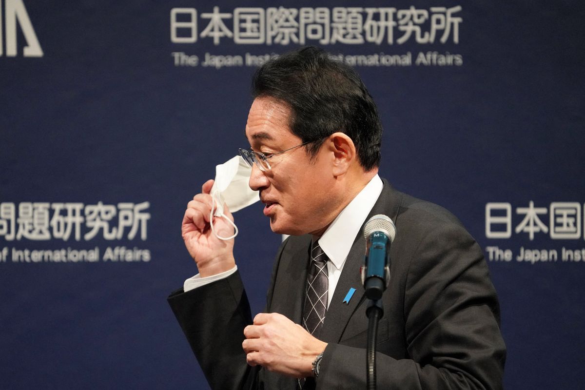 Japan's Prime Minister Fumio Kishida takes off his face mask before his speech at the opening of the 4th Tokyo Global Dialogue in Tokyo on February 20, 2023. 