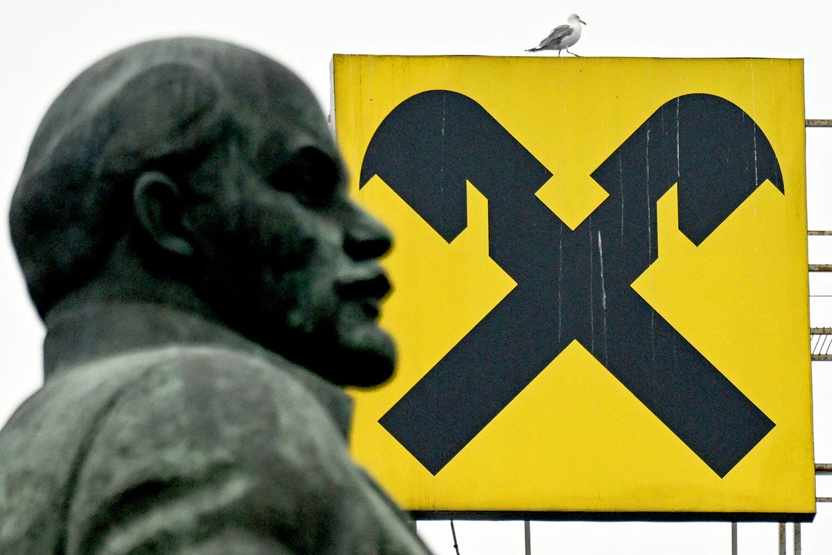 Seagull walks on a logo of Raiffeisen bank atop a building behind a monument of Soviet country founder Vladimir Ulyanov, also known as Lenin in Moscow on April 12, 2022. (Photo by Kirill KUDRYAVTSEV / AFP)
