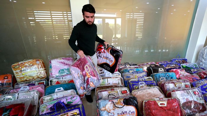 An Iraqi man arranges donation of blankets at the Turkmen Brotherhood Club headquarters in the capital Baghdad on February 8, 2023, to be sent to Turkey and Syria following a deadly earthquake that hit the two countries two days ago. - The death toll from the massive earthquake that struck Turkey and Syria rose above 8,300, official data showed, with rescue workers still searching for trapped survivors. (Photo by AHMAD AL-RUBAYE / AFP)