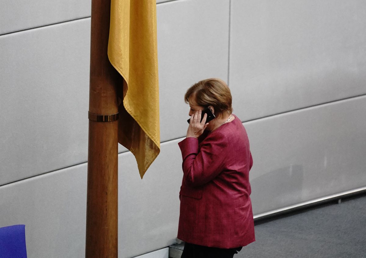 30 September 2020, Berlin: Chancellor Angela Merkel (CDU) is on the phone during the general debate on the federal budget in the Bundestag.