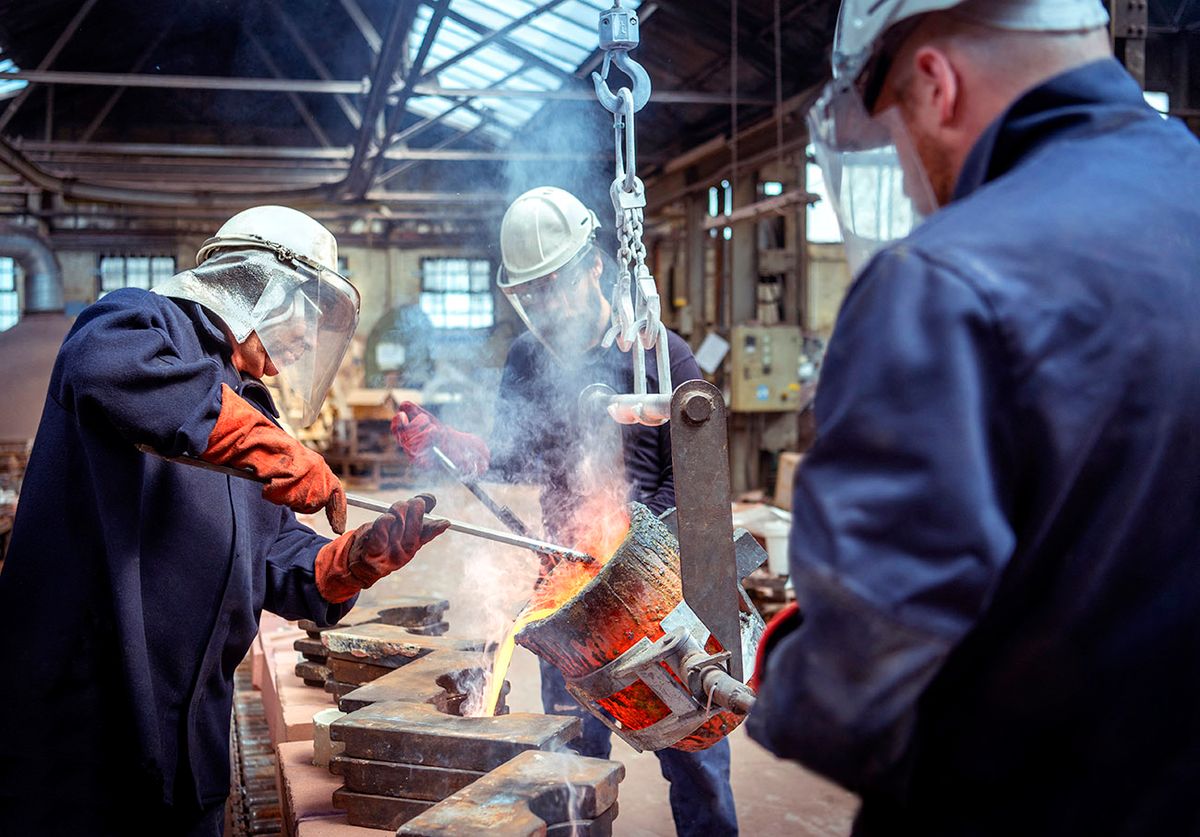 Workers pouring molten brass in brass foundry (Photo by Monty Rakusen / Image Source / Image Source via AFP)