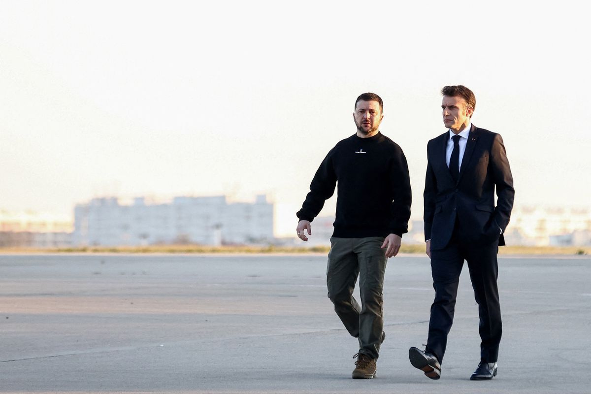 France's President Emmanuel Macron (R) and Ukrainian President Volodymyr Zelensky walk on the tarmac of Velizy-Villacoublay airbase as they prepare to board a flight together, en route to Brussels for a summit at EU parliament, on February 9, 2023. - Ukraine's President is set to attend an EU summit in Brussels on February 9, 2023, as the guest of honour where he will press allies to deliver fighter jets "as soon as possible" in the war against Russia. 