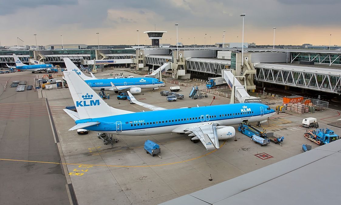 Schiphol,,The,Netherlands,-,August,24,2012:,Terminal,And,Schiphol, The Netherlands - August 24 2012: Terminal and a row of parked airplanes on Amsterdam Airport Schiphol under a gloomy sky. In front a Boeing 737 of KLM Royal Dutch Airlines Air France.