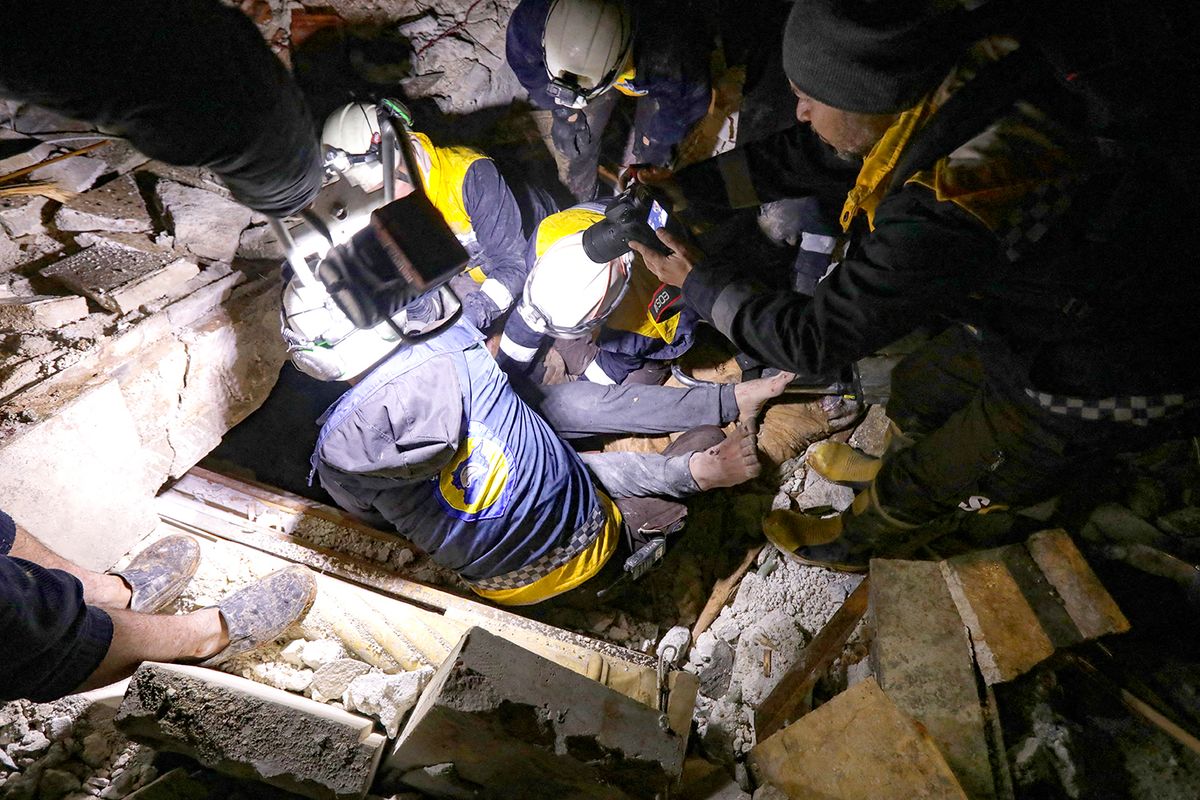 Syrian rescuers (White Helmets) retrieve an injured man from the rubble of a collapsed building  follwoing an earthquake, in the border town of Azaz in the rebel-held north of the Aleppo province, early on February 6, 2023, - At least 42 have been reportedly killed in north Syria after a 7.8-magnitude earthquake that originated in Turkey and was felt across neighbouring countries. (Photo by Bakr ALKASEM / AFP)