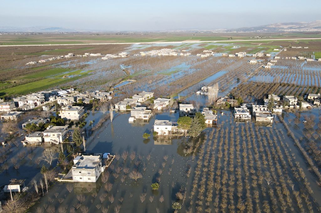 An aerial view shows the flooding in the rebel-held Syrian village of Tloul, near the Turkish border on February 9, 2023, after a dam collapsed in the aftermath of a deadly earthquake that struck Turkey and Syria. - Streets, wheat and bean fields were completely flooded in the village near the Turkish border. Dozens of families left their homes to seek refuge in nearby towns, as water partially submerged houses and trees. (Photo by MUHAMMAD HAJ KADOUR / AFP)