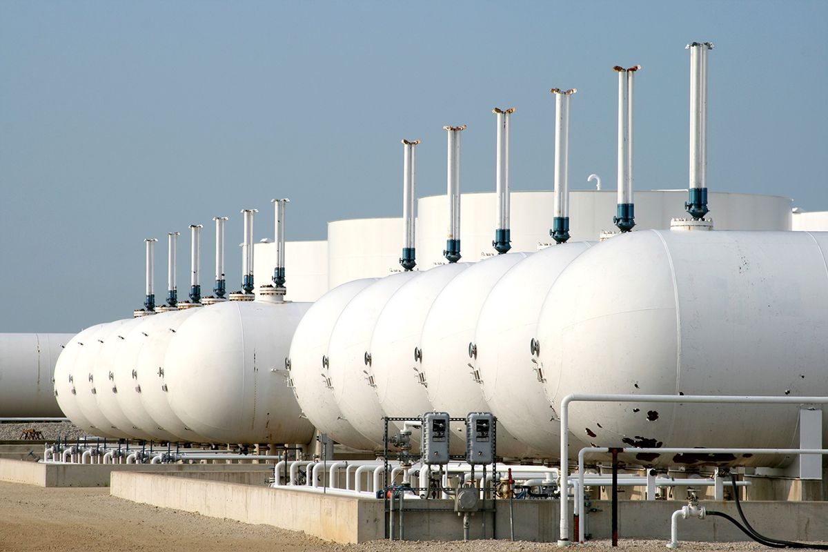 Oil Tanks "A row of holding tanks in an oil refinery, larger tanks are in the background"