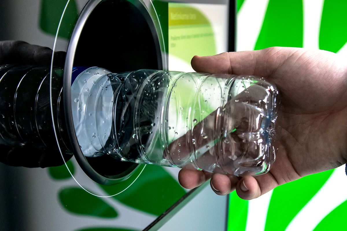 Reverse,Vending,Recycling,Machine.,Recycling,Machine,That,Dispenses,Cash.,Man Reverse Vending Recycling Machine. Recycling machine that dispenses cash. Man hand puts plastic bottle to the machine