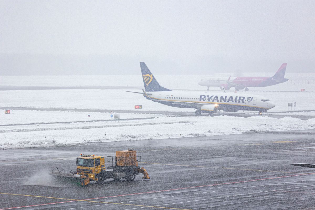 Ryanair Boeing 737-800 Landing During A Snow Storm In The Netherlands
A Boeing 737-800 aircraft of the Irish low cost carrier Ryanair is taxiing, a WizzAir Airbus A321 is going for take off during a snow storm in Eindhoven Airport in the Netherlands on January 20, 2023 while an orange vehicle, is cleaning the tarmac . The arriving Ryanair passenger jet airplane has the registration EI-DYZ. The Dutch Weather Institute KNMI issued a Code Orange, Snowfall in several Dutch provinces suggesting commuters urged to work from home as the snow caused dangerous conditions in several Dutch provinces on Friday morning. The KNMI issued a code orange warning for Utrecht, Gelderland, Noord-Brabant, and Limburg while code yellow for icy roads warning also covers the entire country. (Photo by Nicolas Economou/NurPhoto via Getty Images)