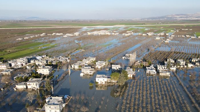 An aerial view shows the flooding in the rebel-held Syrian village of Tloul, near the Turkish border on February 9, 2023, after a dam collapsed in the aftermath of a deadly earthquake that struck Turkey and Syria. - Streets, wheat and bean fields were completely flooded in the village near the Turkish border. Dozens of families left their homes to seek refuge in nearby towns, as water partially submerged houses and trees. (Photo by MUHAMMAD HAJ KADOUR / AFP)