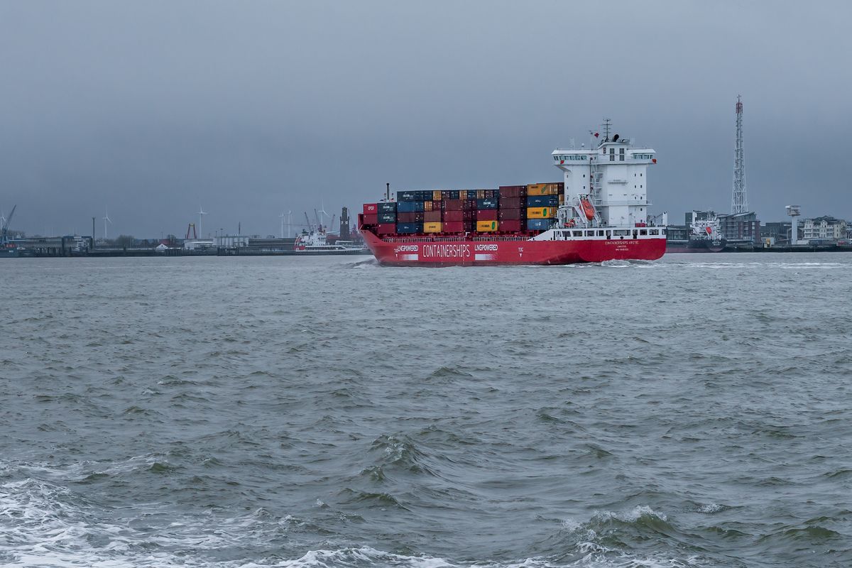Cuxhaven, Germany - 02.25.2022: Fully loaded container cargo ship with CONTAINERSHIPS letters on its side sailing into the port of Cuxhaven. Supply chain crisis. Sanctions against Russia.