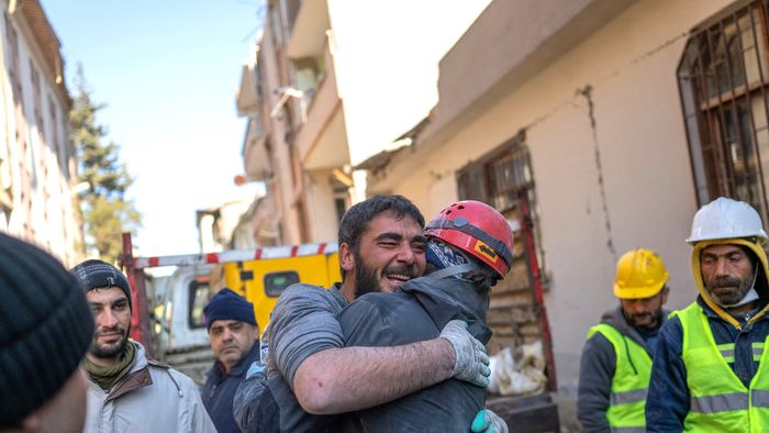 Egy bányász (L), aki megmentette a 16 éves Meldát, miután három napig rekedt a romokban, reagált egy mentőcsapat egyik tagjával