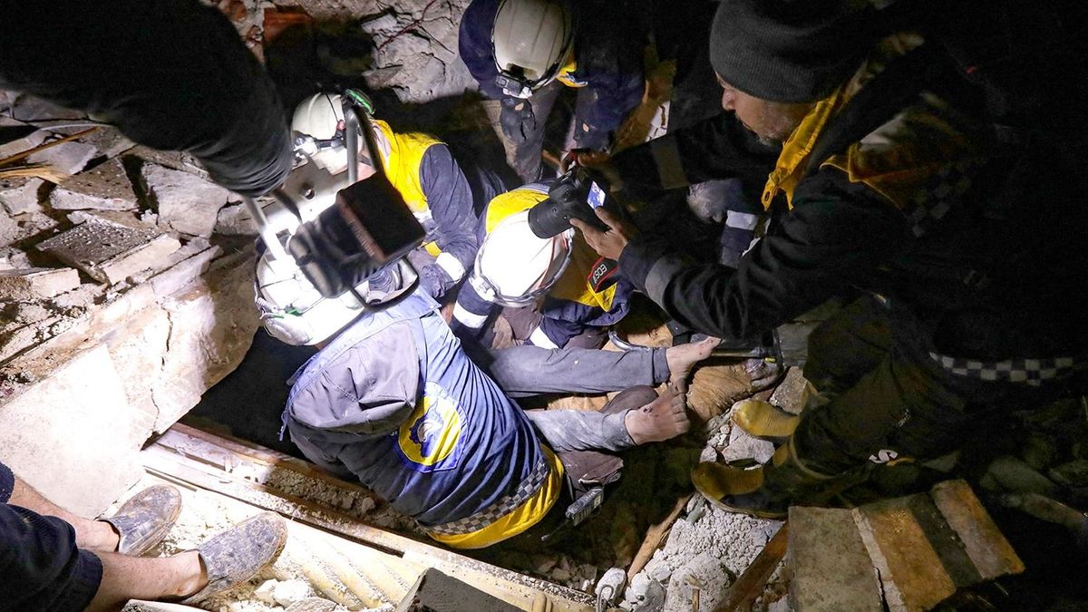 Syrian rescuers (White Helmets) retrieve an injured man from the rubble of a collapsed building  follwoing an earthquake, in the border town of Azaz in the rebel-held north of the Aleppo province, early on February 6, 2023, - At least 42 have been reportedly killed in north Syria after a 7.8-magnitude earthquake that originated in Turkey and was felt across neighbouring countries. (Photo by Bakr ALKASEM / AFP)