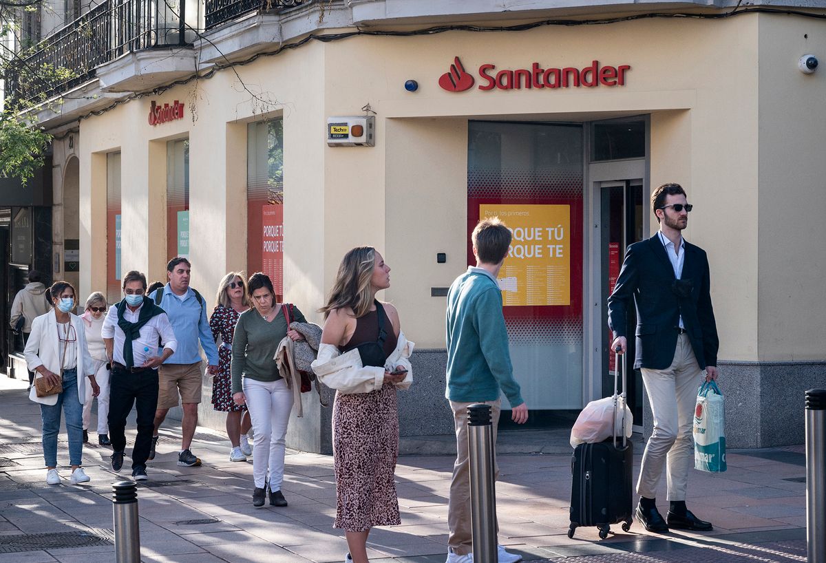 Pedestrians walk past the Spanish multinational commercial