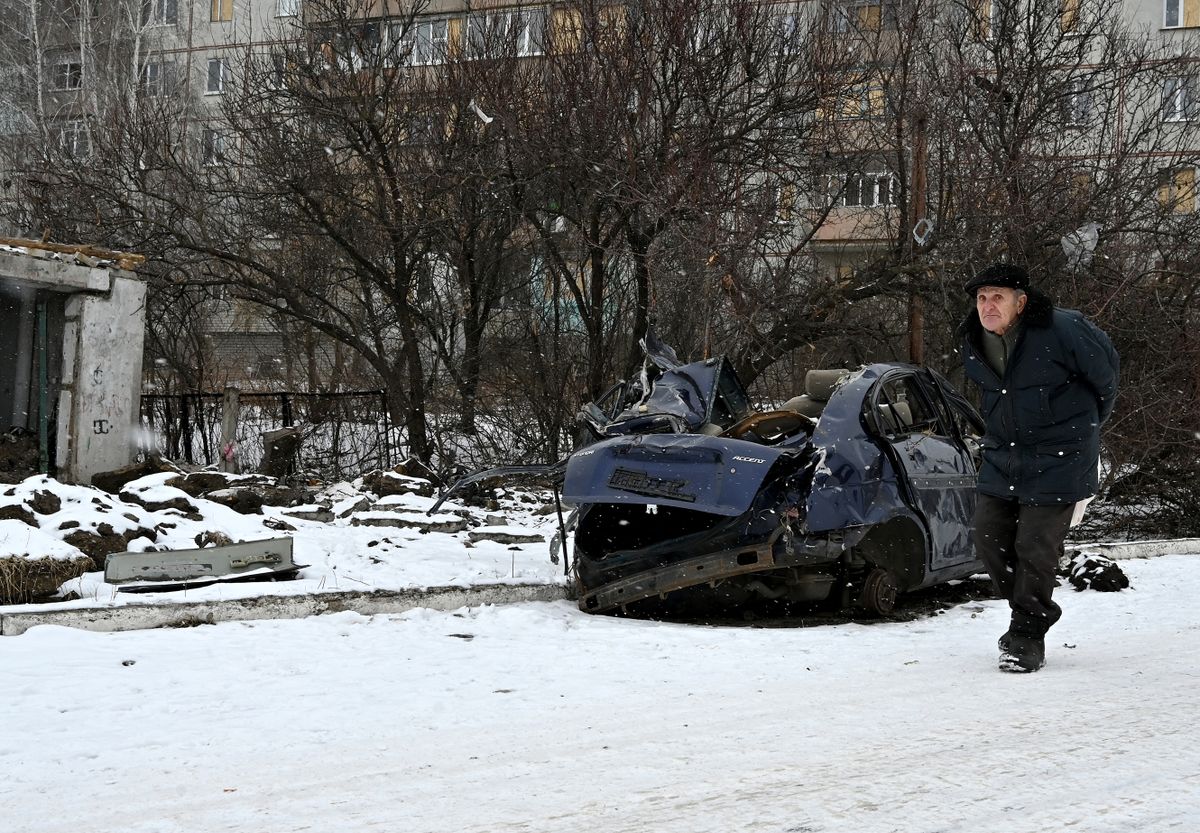 A local resident walks past a destroyed car in Kupiansk, Kharkiv region, on February 13, 2023.
orosz-ukrán