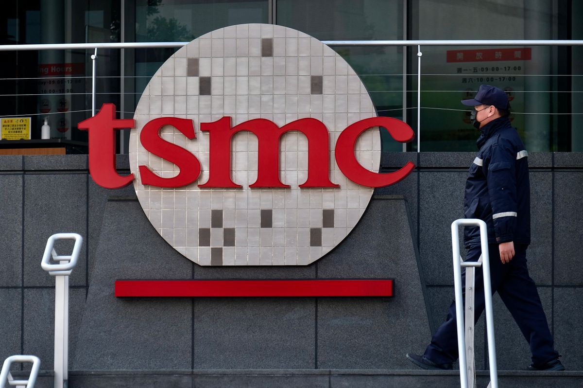A guard walks past a company logo at the headquarters of the world's largest semiconductor maker TSMC in Hsinchu on January 29, 2021. 
