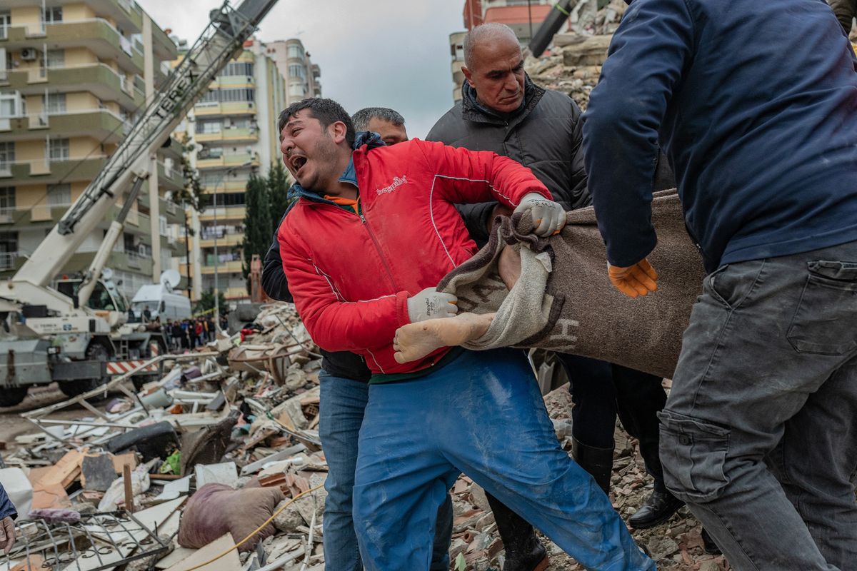 A rescuer reacts as he carries a body found in the rubble in Adana on February 6, 2023, after a 7.8-magnitude earthquake struck the country's south-east. - The combined death toll has risen to over 1,900 for Turkey and Syria after the region's strongest quake in nearly a century on February 6, 2023. Turkey's emergency services said at least 1,121 people died in the 7.8-magnitude earthquake, with another 783 confirmed fatalities in Syria, putting that toll at 1,904. 