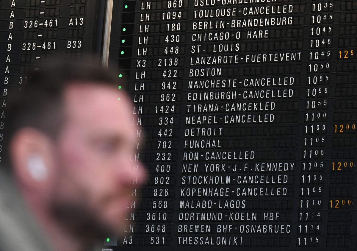 15 February 2023, Hesse, Frankfurt/Main: A passenger stands in front of the display board showing departures at Frankfurt Airport in Terminal 1. Due to an IT glitch at the Lufthansa Group, thousands of passengers were affected by delays and flight cancellations on Wednesday (15.02.2023 ). 