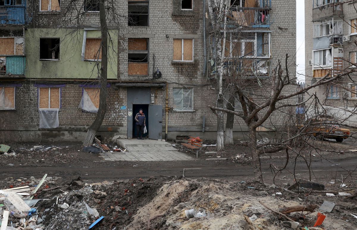 A local resident stands in the doorway of a building partially destroyed by Russian shelling in Ukrainian town of Kupiansk, Kharkiv region on March 7, 2023. 