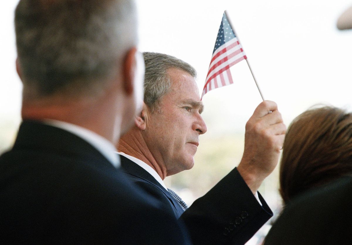 WASHINGTON - OCTOBER 11:  (NO U.S. TABLOID SALES)  President George W. Bush holds the American flag as he attends a memorial service for the victims of the September 11, 2001 terrorist attack on the Pentagon October 11, 2001 in Washington, DC.  