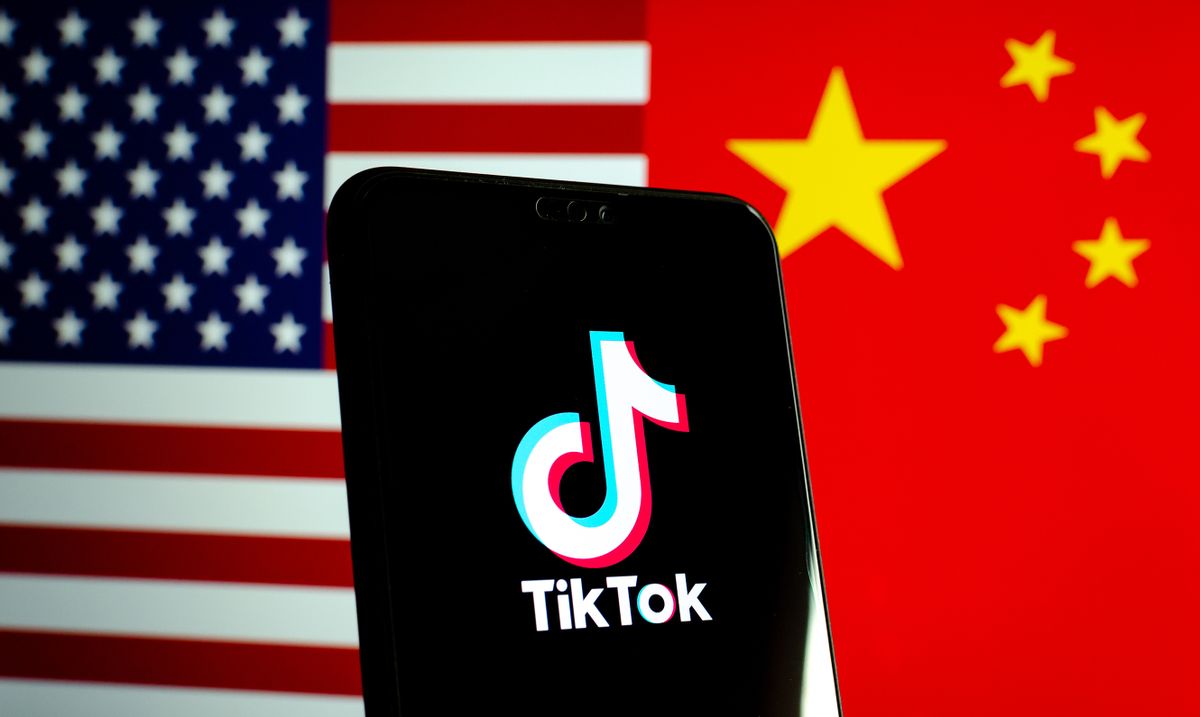 Stone / UK - October 25 2019: TikTok app logo on a smartphone screen and flags of China and United States. Tiktok WeChat are banned. Apps are in centre of US - China tensions and security concerns.