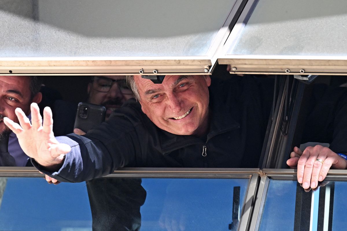 Former Brazilian President Jair Bolsonaro greets supporters from a window at the Liberal Party headquarters in Brasilia on March 30, 2023. - Three months after leaving for the United States in the final hours of his term, Brazil's ex-president Jair Bolsonaro returned home Thursday to reenter politics -- complicating life for his successor and nemesis, Luiz Inacio Lula da Silva. The far-right ex-army captain, who skipped town two days before Lula's inauguration on January 1, arrived back in Brasilia on a commercial flight from Orlando, Florida. 