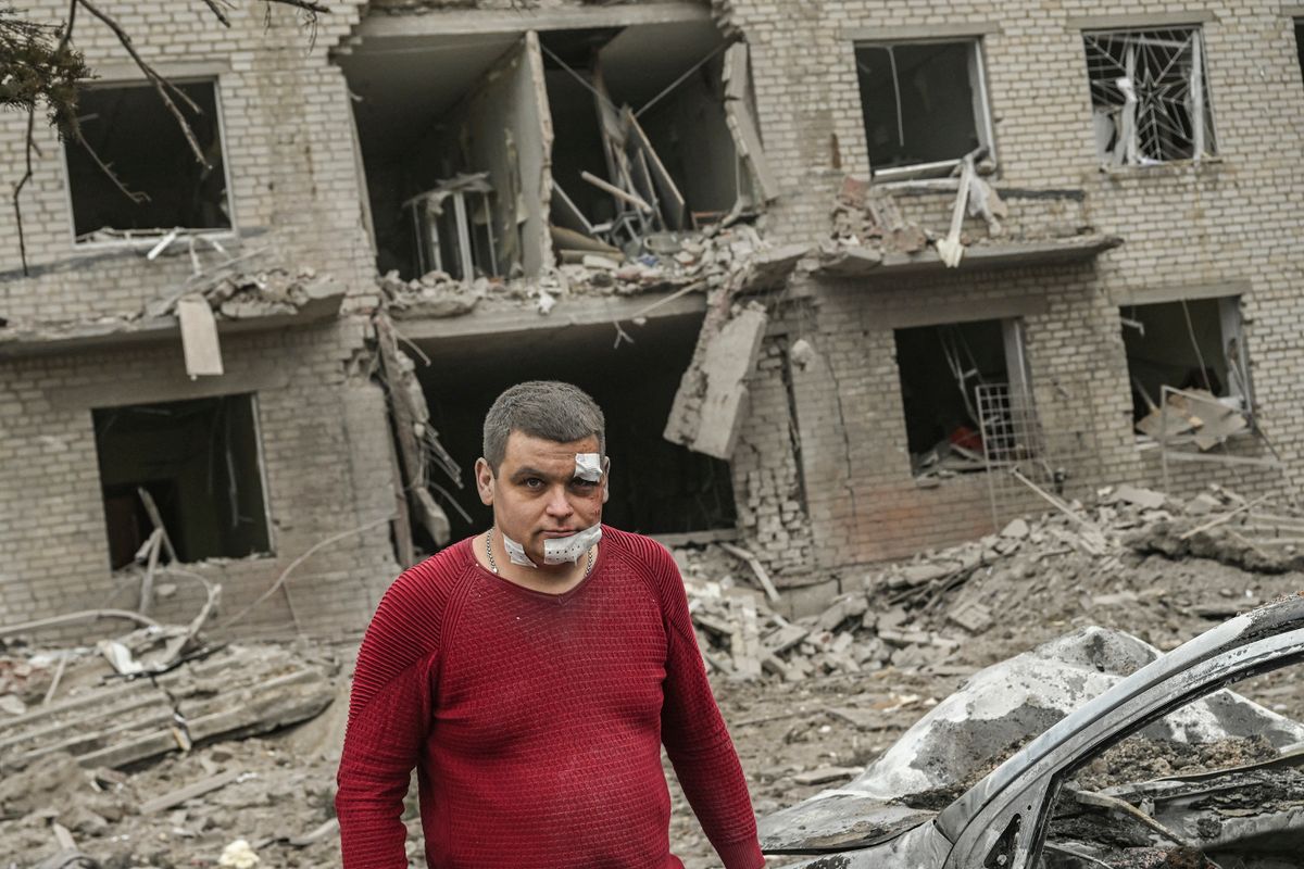 An injured man stands in front of destroyed building after a deadly strike in the city of Sloviansk, on March 27, 2023. - Shelling of the eastern Ukraine town of Sloviansk on March 27, 2023, killed at least two people and wounded more than two dozen others, authorities sai