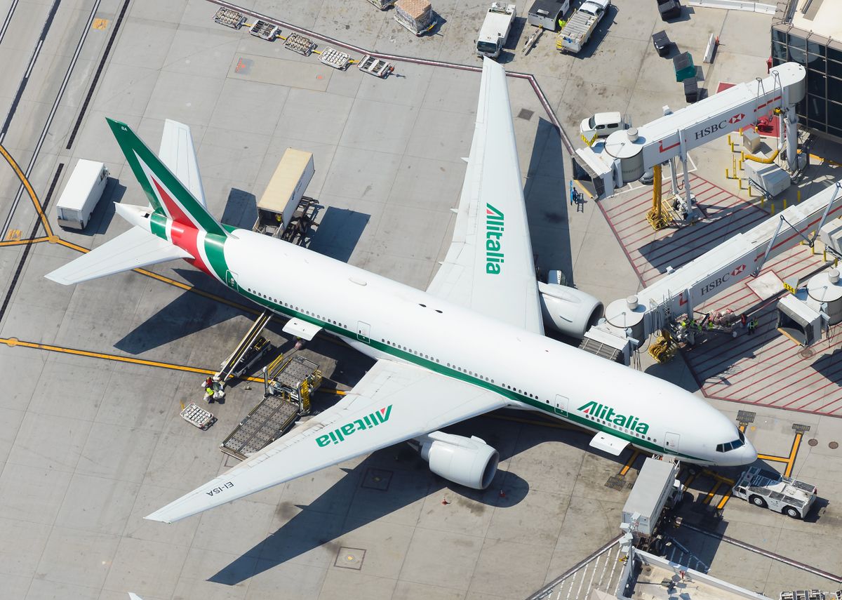 Los Angeles, CA / USA - May 30 2016: Alitalia Boeing 777-200ER parked at LAX International Airport. Long haul 777 aircraft registered as EI-ISA before departure to Rome Fiumicino, Italia. Aerial view.